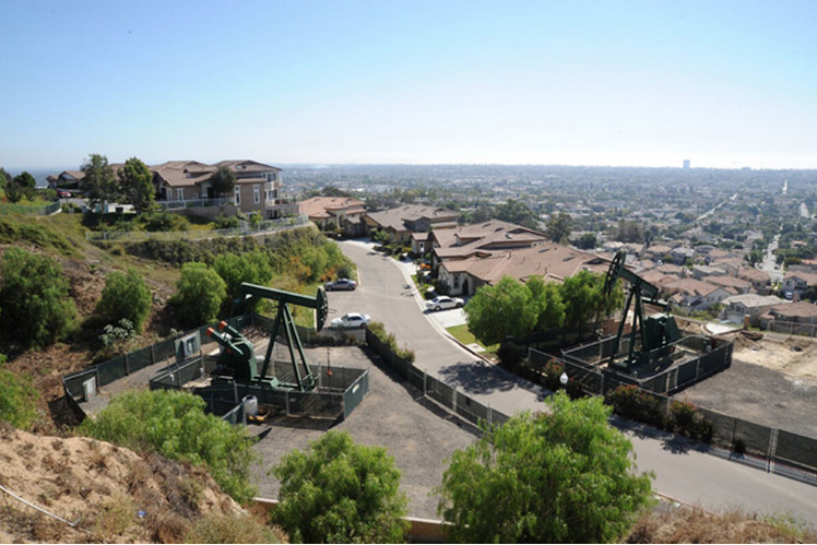A residential neighborhood with oil derricks in Signal Hill, CA. Photo courtesy of the Center for Land Use Interpretation, Los Angeles.