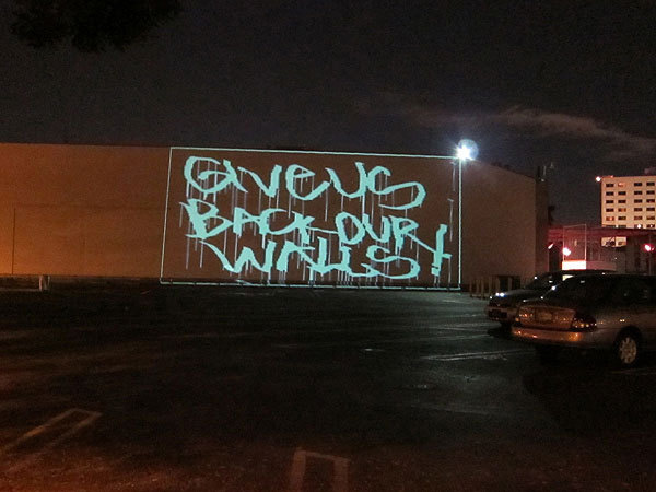 A guerrilla performance at MOCA's Geffen Contemporary in early January used projected graffiti to protest the whitewashing of a mural by Blu. Photo: Deborah Vankin.